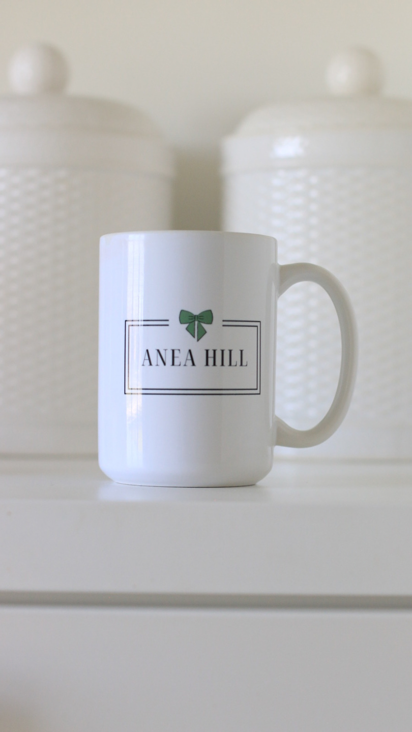 ANEA HILL white logo mug sitting on a counter perfect for coffee or tea
