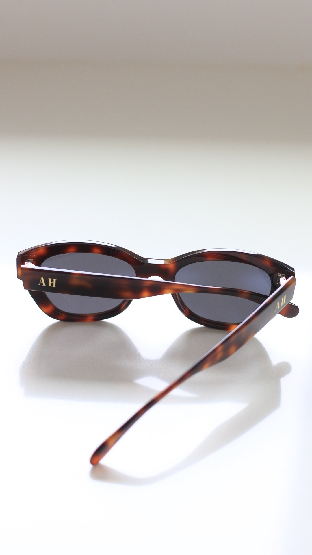 Pictured: THe back and side arms of 1946 small tortoise sunglasses with gold AH logo on the sides. Discover ANEA HILL, a top choice for Best Women Sunglass Brand.