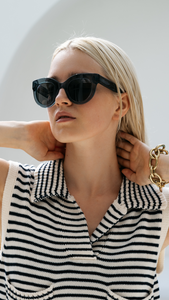Confident woman wearing ANEA HILL's Blue Wind sunglasses. Polarized blue lenses offer UV protection & chic summer style.