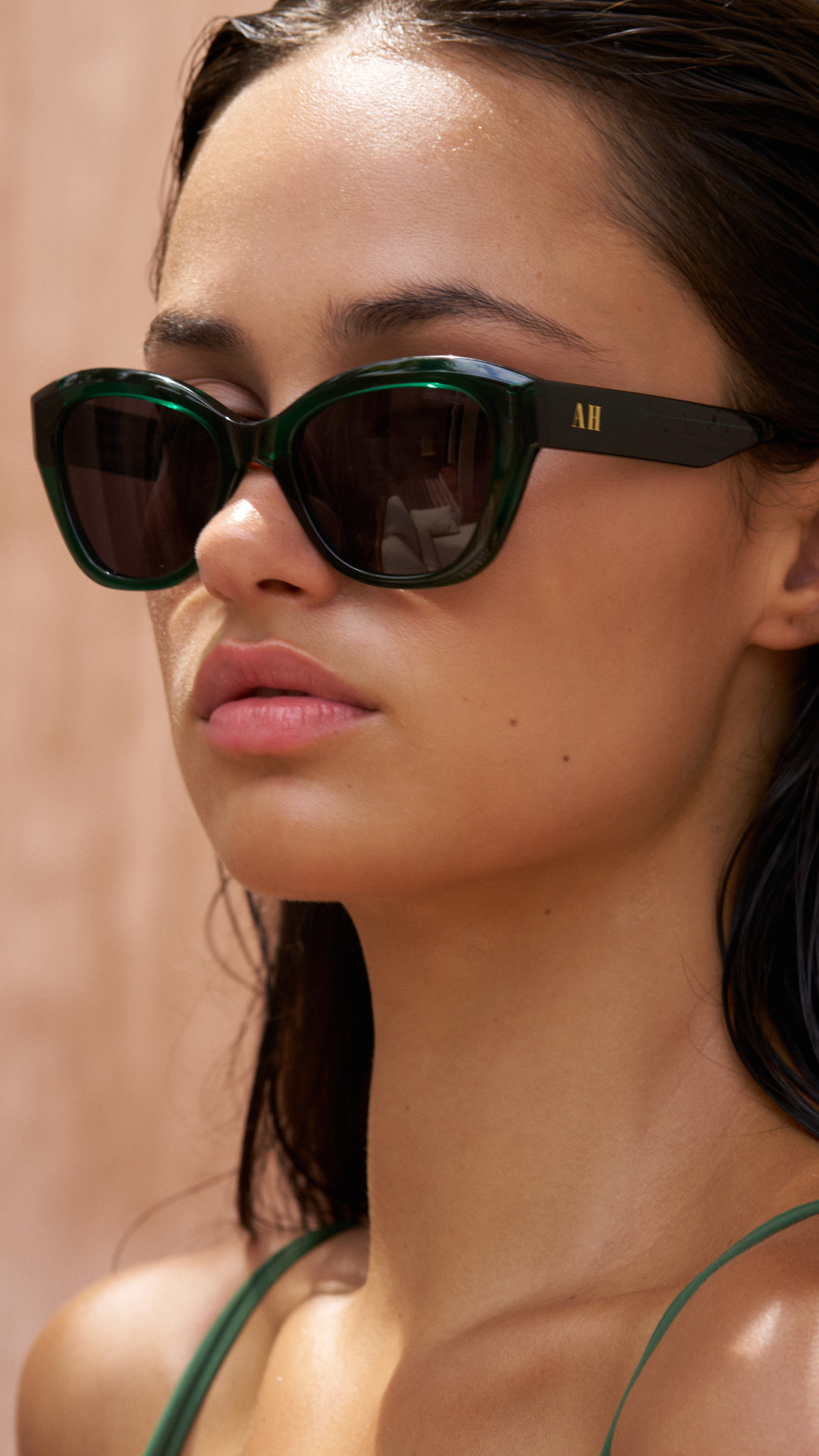 Translucent green luxury sunglasses for women fitting on a small face, smaller face with ANEA HILL AH logo on the side in gold.