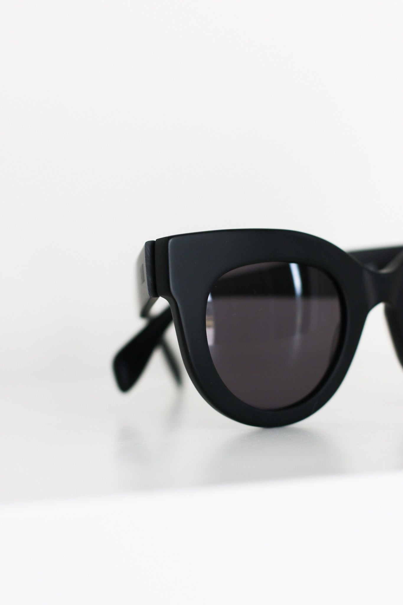 Close-up of Manhattan luxury oversized sunglasses, featuring dark-gray tinted lenses and matte black acetate frames.