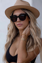 Load image into Gallery viewer, Model wearing black luxury sunglasses, The One, by ANEA HILL.
