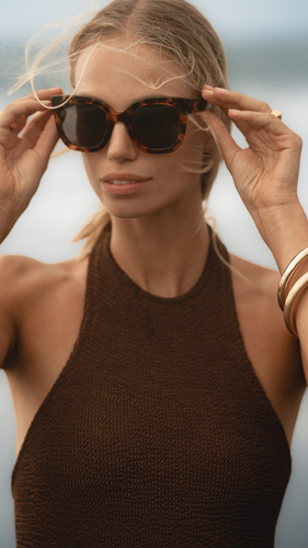 Our model wearing ANEA HILL's high-end Sunset Sunglasses, showcasing the oversized square frames and dark-tinted lenses for a chic and sophisticated look.
