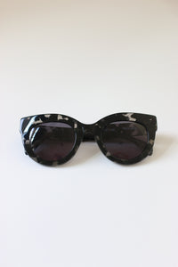 Sunglasses for women with black & clear tortoise acetate frames and oversized cat-eye shape.