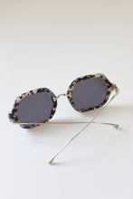 Load image into Gallery viewer, The side view of ANEA HILL&#39;s luxury sunglasses showcases their silver-tone arm, bridge, and hinges, as well as their dark-gray tinted lenses.
