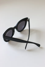 Load image into Gallery viewer, Back view of luxury oversized sunglasses with silver-tone hinges and matte black acetate frames.
