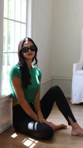 Model in luxury oversized sunglasses, wearing Anea Hill Manhattan sunglasses, sitting on the floor and in the sun